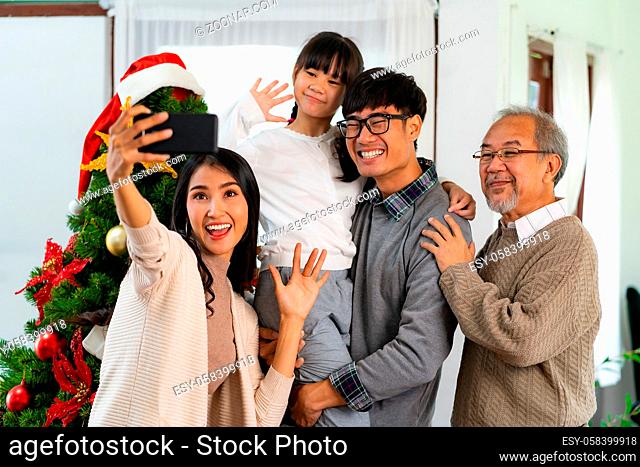 Multigenerational asian Family , Mom Dad daughter girl and grandfather , selfie with a Christmas tree after decorate the Christmas ornament prepare season...