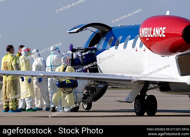 02 April 2020, Saxony, Dresden: A seriously ill Covid 19 patient from France is being transported from an ambulance plane at Dresden International Airport