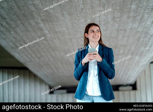 Female professional holding mobile phone at basement