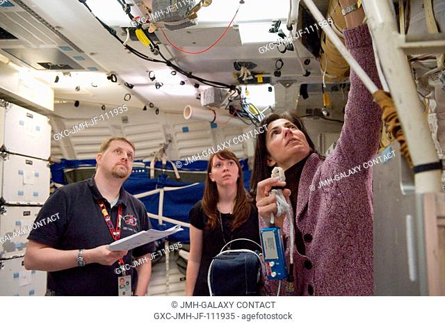 NASA astronaut Nicole Stott (right), STS-133 mission specialist, participates in training session in a shuttle mock-up in the Space Vehicle Mock-up Facility at...