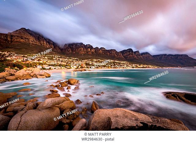 Long exposure at sunset at Camps Bay with cloud over Table Mountain and the Twelve Apostles, Cape Town, South Africa, Africa