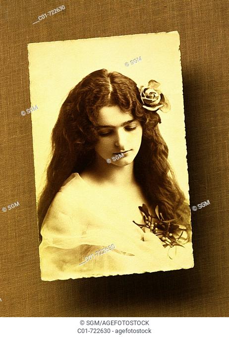 Antique picture of a long-haired young woman with a rose, 1920's