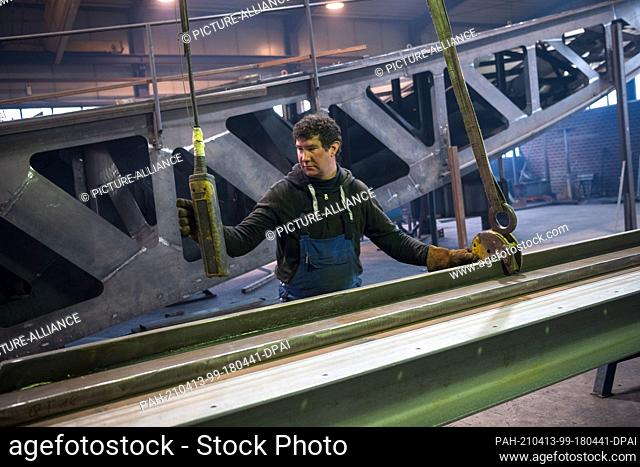 12 April 2021, North Rhine-Westphalia, Stemwede: Carsten Balshüsemann, metalworker, works next to one of the components of the future Freedom and Unity Monument...