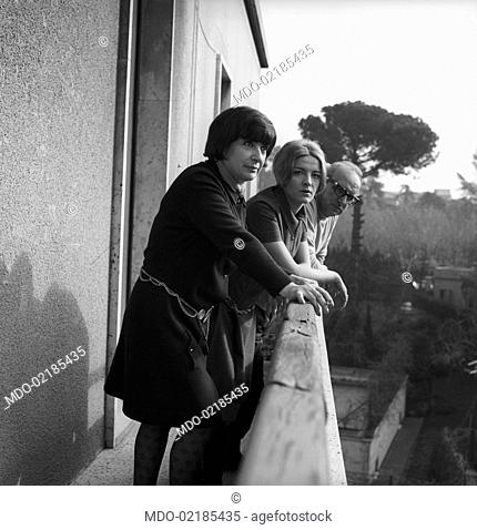 Italian writer Vasco Pratolini at home appearing at the balcony with his wife Cecilia Punzo and his daughter Aurelia. Rome, 1969