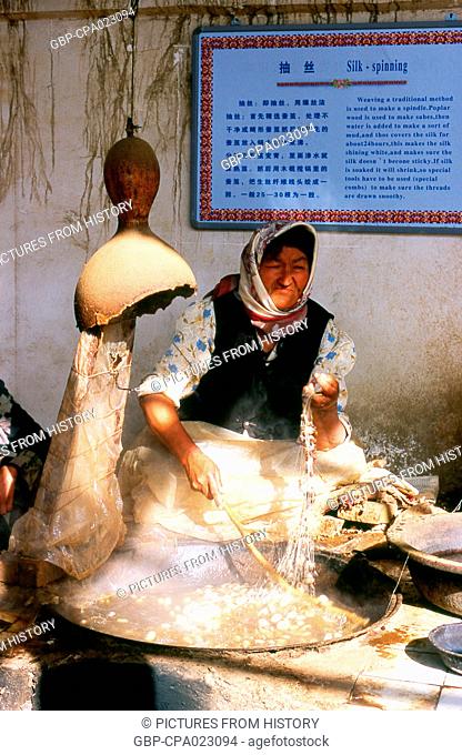 China: Uighur woman spinning silk, Atlas Silk Workshop (Atlas Karakhana) in Jiya Village, about 13km northeast of Khotan, Xinjiang Province
