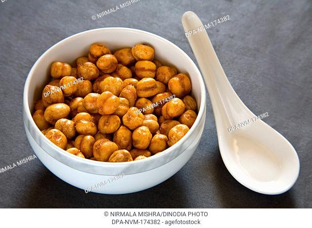 Indian breakfast fry chickpeas chana masala served in bowl with spoon on black background 12-May-2010