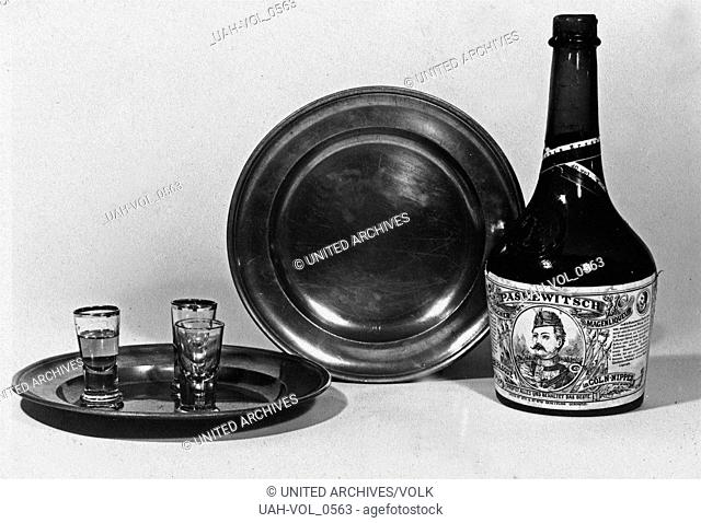 Drei Schnapsgläser, zwei Zinnteller und eine Flasche Paskewitsch Magenbitter Kräuterlikör, als Stilleben arrangiert, Deutschland 1930er Jahre