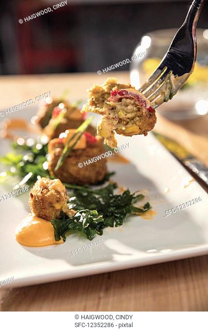 Crawfish corn fritters on a fork and plate