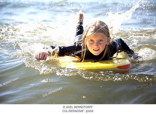 Portrait of girl on surfboard, Wales, UK