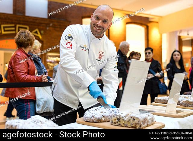 02 November 2022, Brandenburg, Cottbus: Master baker Rene Klinkmüller from the Klinkmüller confectionery in Luckau cuts Stollen for the public tasting as part...