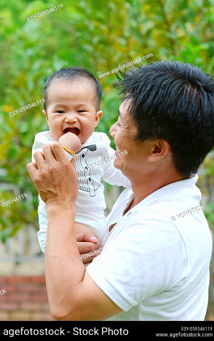 Happy father's day! joyful young dad hugging his cute son at outdoor park