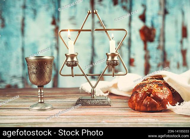 Shabbat candles in glass candlesticks of covered challah bread