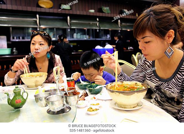 Customers in a restaurant having 'guoqiao mi xian' (Crossing the bridge noodles) a kind of rice noodle soup from Yunnan, Kunming, China