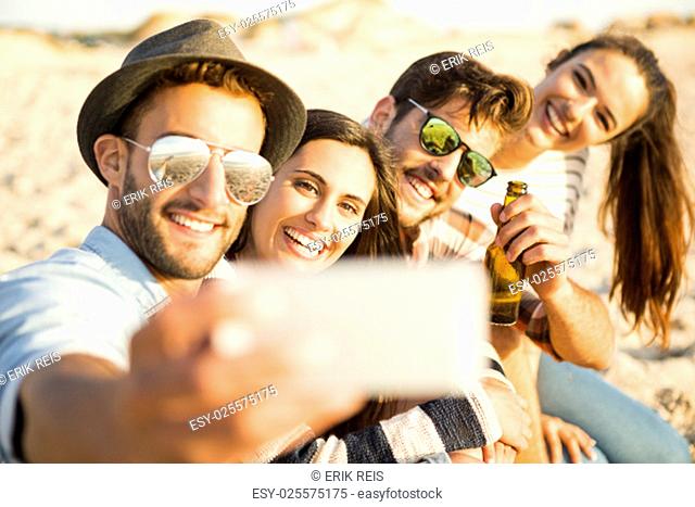 Group of friends at the beach making a selfie together