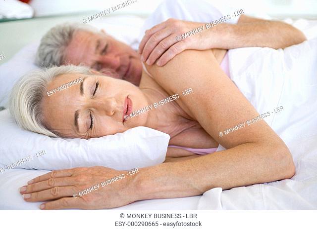 Couple lying in bed together sleeping