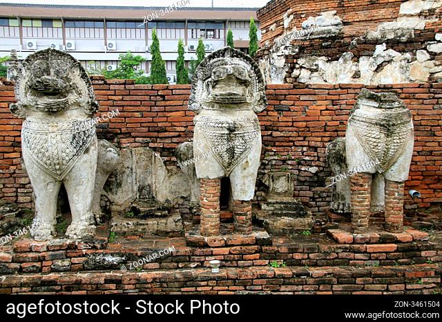 Stone lions and basement of brick stupa in Wat Thummikarat, Ayutthaya, Thailand