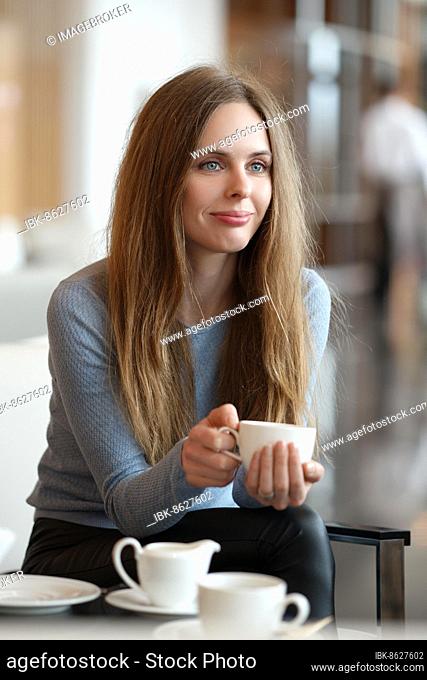 Beautiful young women drinking coffee in a cafe. Shallow depth of field