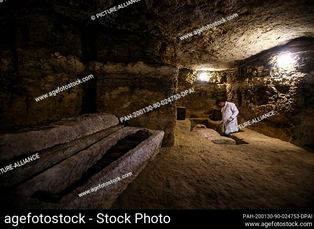 30 January 2020, Egypt, Minya: An archaeologist works inside a communal tomb, one of three newly discovered tombs of the high priests of ancient Egyptian deity...