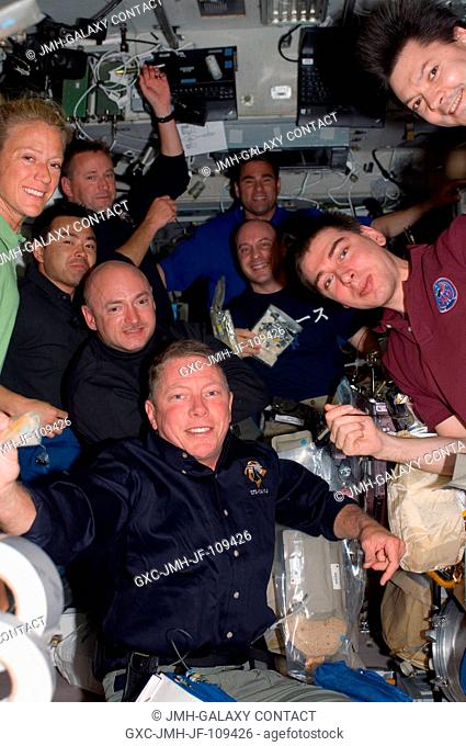 Nine of ten astronauts and cosmonauts currently sharing work on the International Space Station squeeze into an informal group portrait during mealtime on the...
