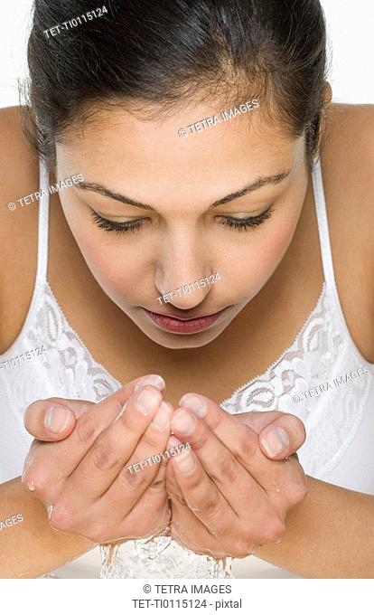 Woman with water cupped in hands