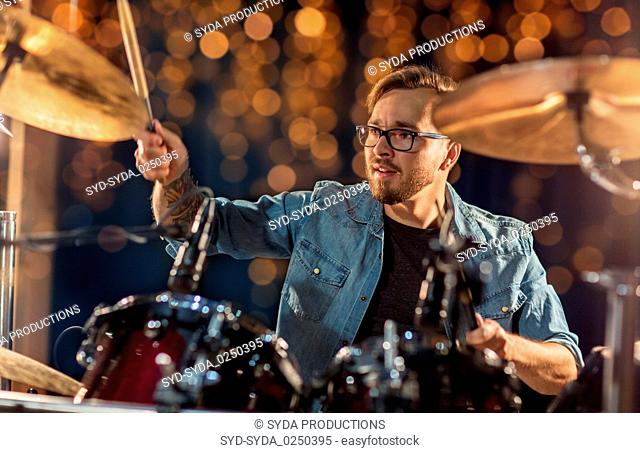 male musician playing drums and cymbals at concert