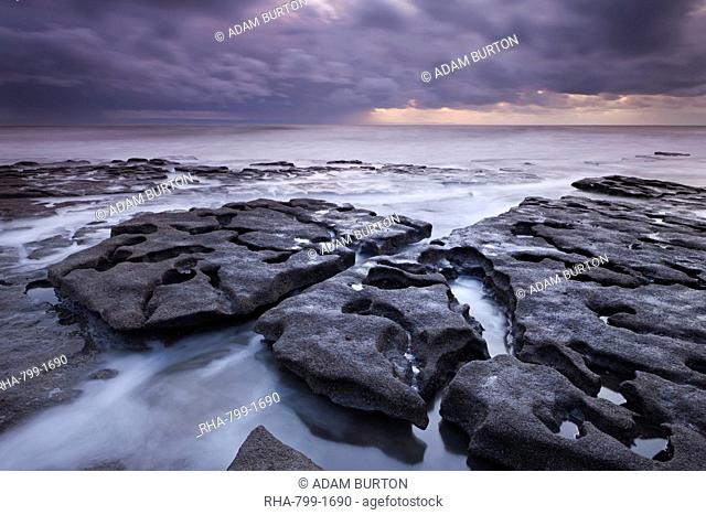 Waves rush around eroded rock ledges at Southerndown on the Glamorgan Heritage Coast, Wales, United Kingdom, Europe