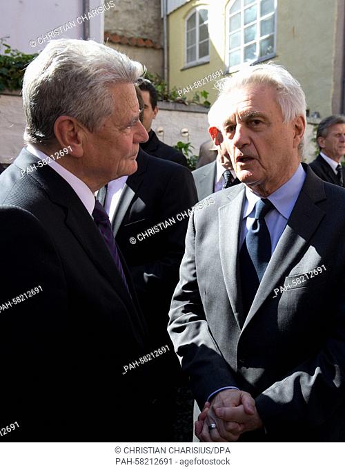 German President Joachim Gauck (L) and US-American author John Irvins speak at a reception in the garden of the Guenter Grass House after the central memorial...