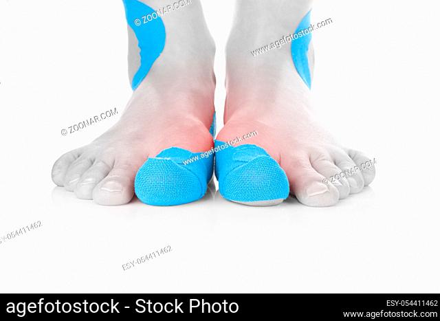 Kinesio tape on female foot isolated on white background. Chronic pain, alternative medicine. Rehabilitation and physiotherapy