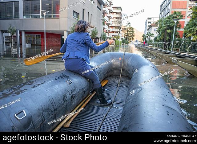 Woman Rowing a Rescue Boat in City of Locarno on Flooding Street in Ticino, Switzerland