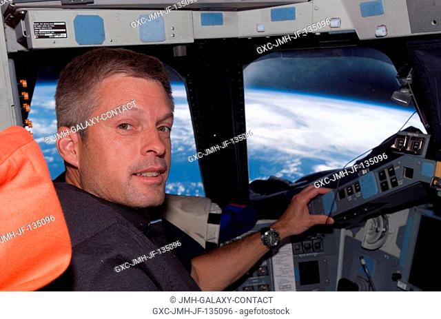 Astronaut Steven Swanson, STS-117 mission specialist, occupies the commander's station on the flight deck of Space Shuttle Atlantis during flight day 12...