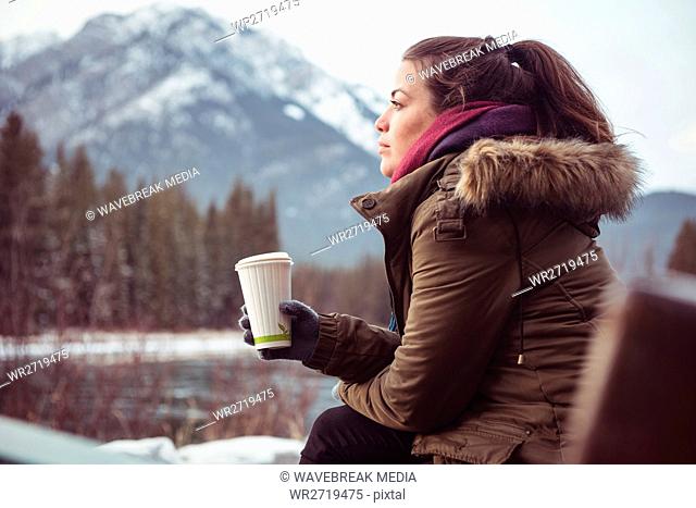 Woman sitting on river bank in winter