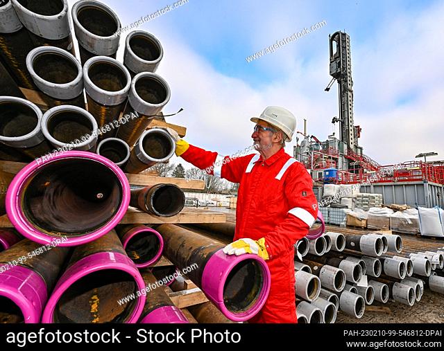 10 February 2023, Brandenburg, Potsdam: Hans-Jürgen Weikert, head of the Drilltec company, stands next to drill pipes on the 33-meter-high derrick at the deep...