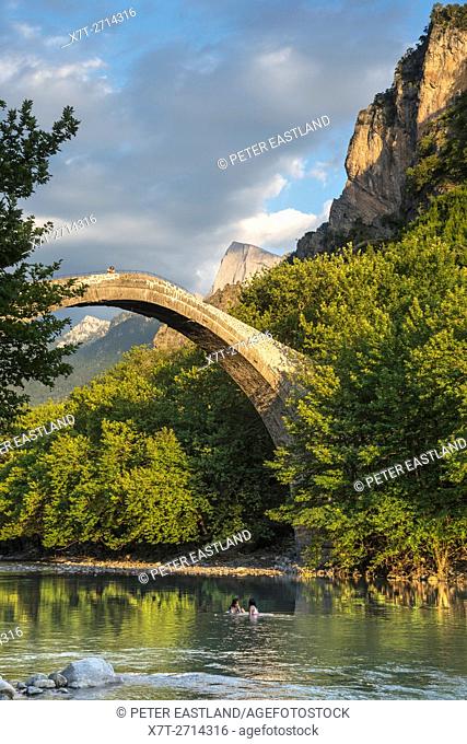 The old stone bridge across the Aoos river at Konitsa with Mount Tymfi in the background, Epirus, Northern Greece