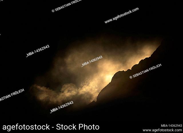 The Wetterstein from Mittenwald in dramatic evening light with dense clouds, partly only the mountain slope
