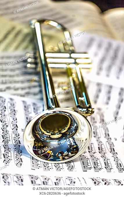 trumpet laying on sheets of music