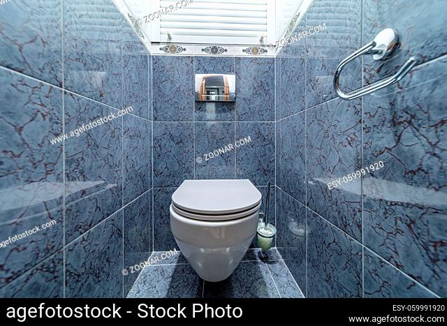 Toilet bowl in the toilet room. Restroom with blue tile decoration
