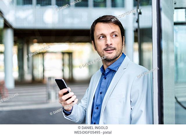 Portrait of a businessman using smartphone in the city