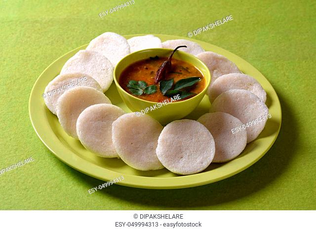 Idli with Sambar in bowl on green background, Indian Dish: south Indian favourite food rava idli or semolina idly or rava idly