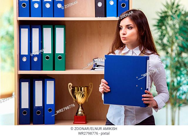 Young businesswoman standing next to shelf