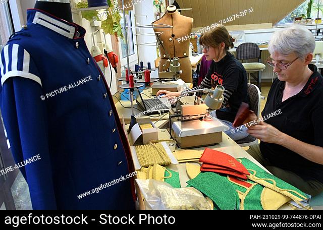 PRODUCTION - 24 October 2023, Thuringia, Altenburg: At Hut und Kostüm GmbH, ladies' tailors Cornelia Windisch (r) and Solveig Nolte sew parts for caps that are...