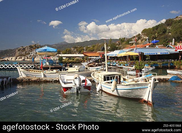 Daily cruise boats anchored inside the harbor near houses and local restaurants in Kalekoy, Ucagiz village, Demre, Antalya Province, Mediterranean Coast