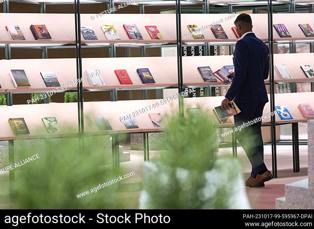 17 October 2023, Hesse, Frankfurt/Main: A man looks at books in the pavilion of the guest of honor Slovenia. The 75th Frankfurt Book Fair will take place from...