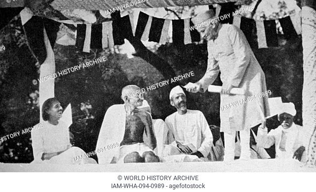 Mahatma Gandhi at a meeting in Allahabad, presided over by Motilal Nehru (standing). Mohandas Gandhi (1869 – 1948) was the preeminent leader of the Indian...