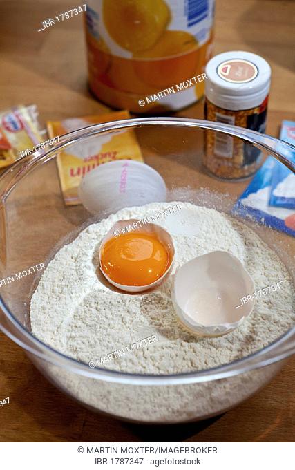 Egg yolk in a bowl of flour, preparation of a cake