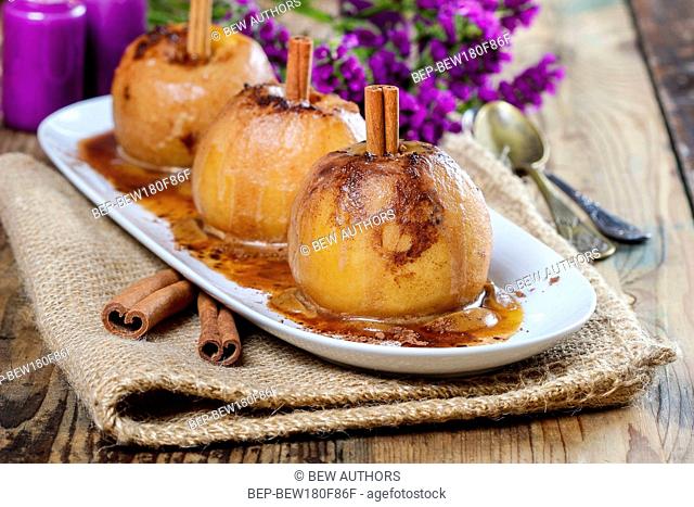Apples with cinnamon on jute napkin. Sea lavender in the background. Healthy autumn dessert