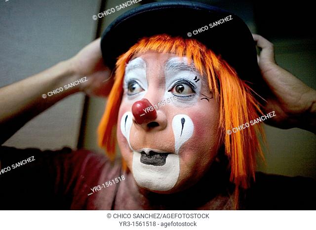 A clown puts on his bowler hat hat as he makes up in his hotel room before attending the 16th International Clown Convention: The Laughter Fair organized by the...