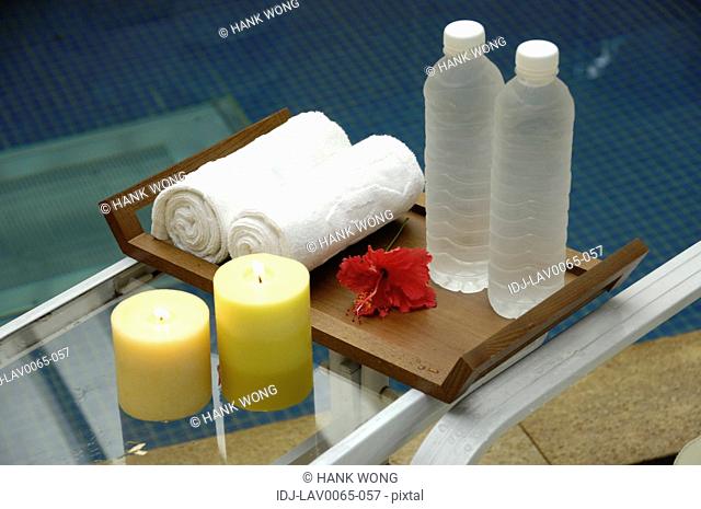 candles burning near rolled towels and water bottles