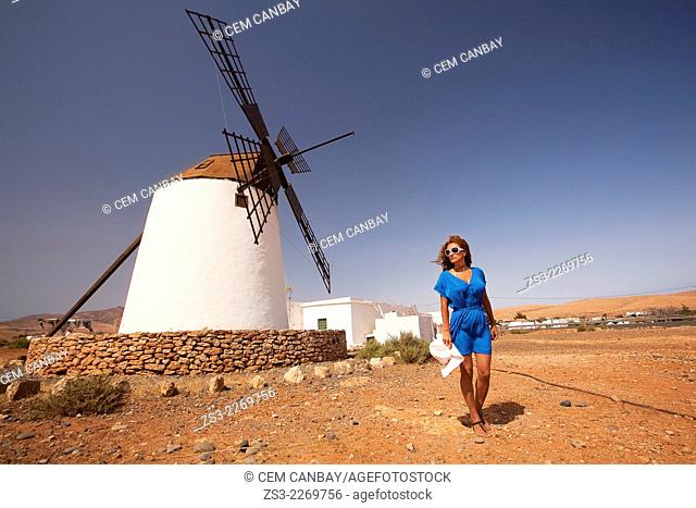 Woman posing in front of the windmill near Antigua, Fuerteventura, Canary Islands, Spain, Europe