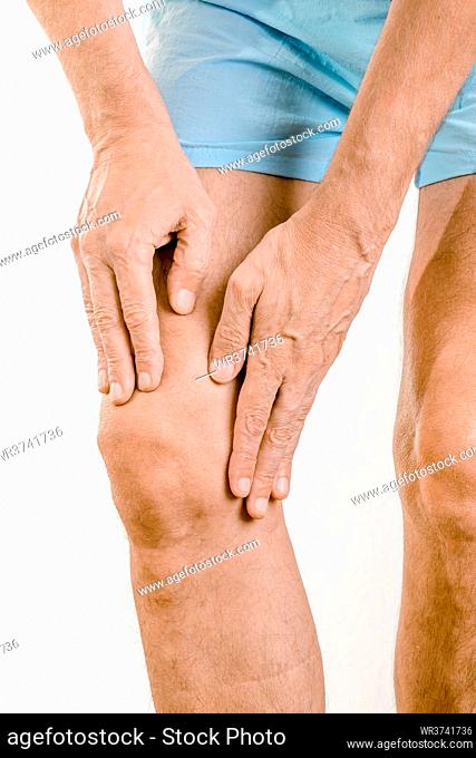 Athlete man massaging a painful quadriceps and the knee after a sport accident. It could be a quadriceps tendinopathy, a muscle elongation