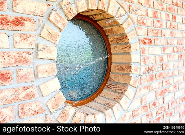 Round window on brick wall - shallow depth of field - focus on the closer arch of the window